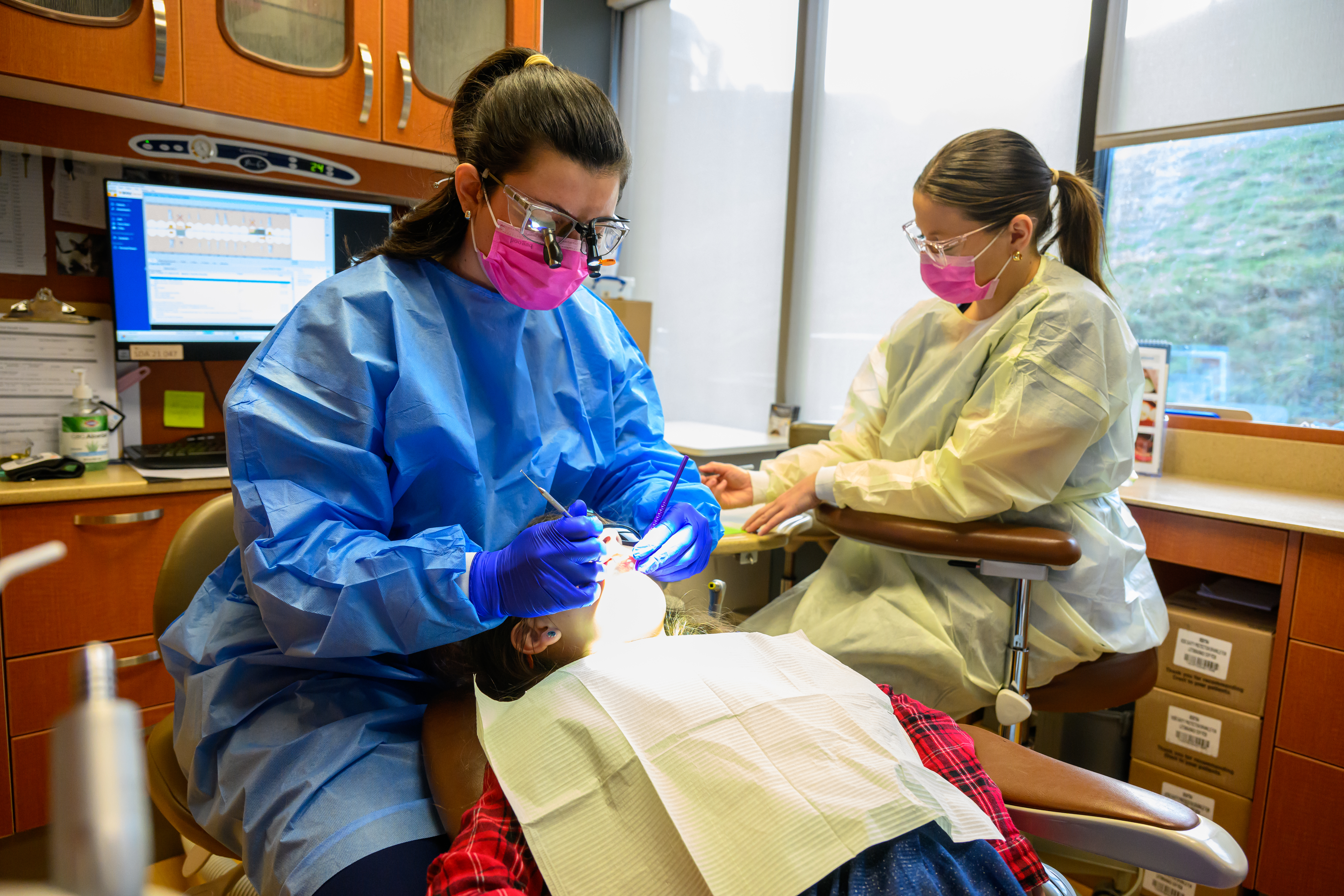 Faculty and students work with a child in the pediatric dentistry clinic. 